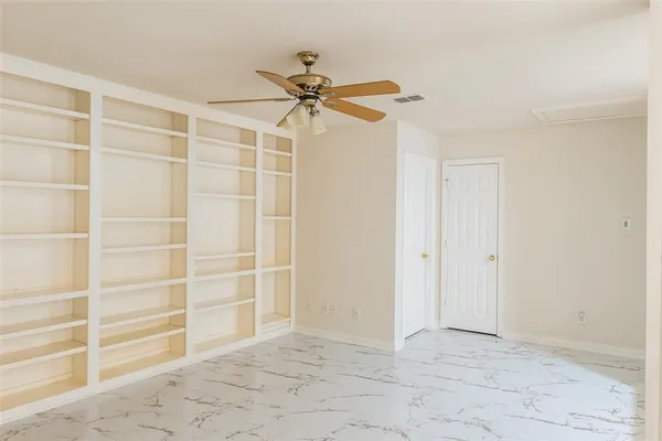 a view of a room with closet and wooden shelves