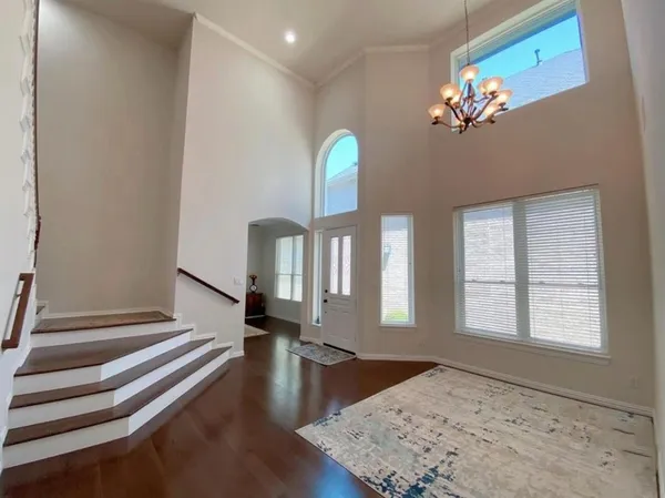 a view of a chandelier fan and wooden floor