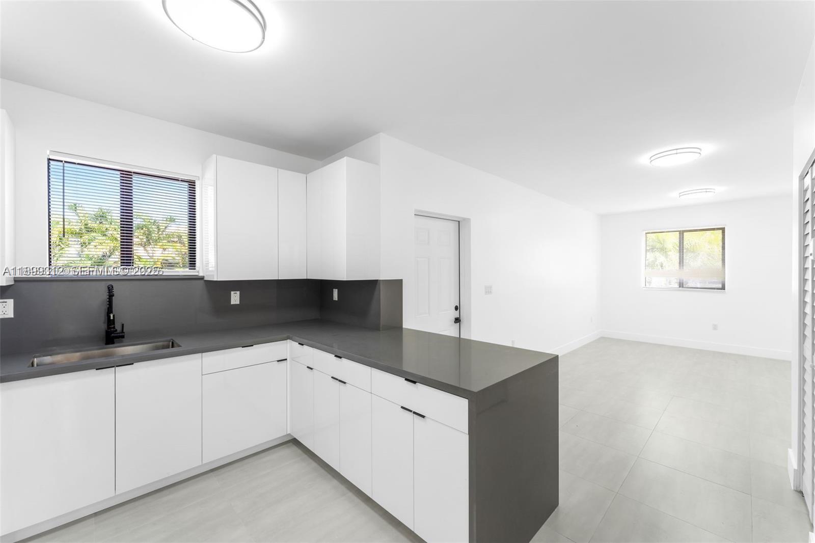 3710 Northwest 13th Place, Unit 1 Miami, FL 33142 - Photo 3 of 8 a kitchen with a sink and cabinets