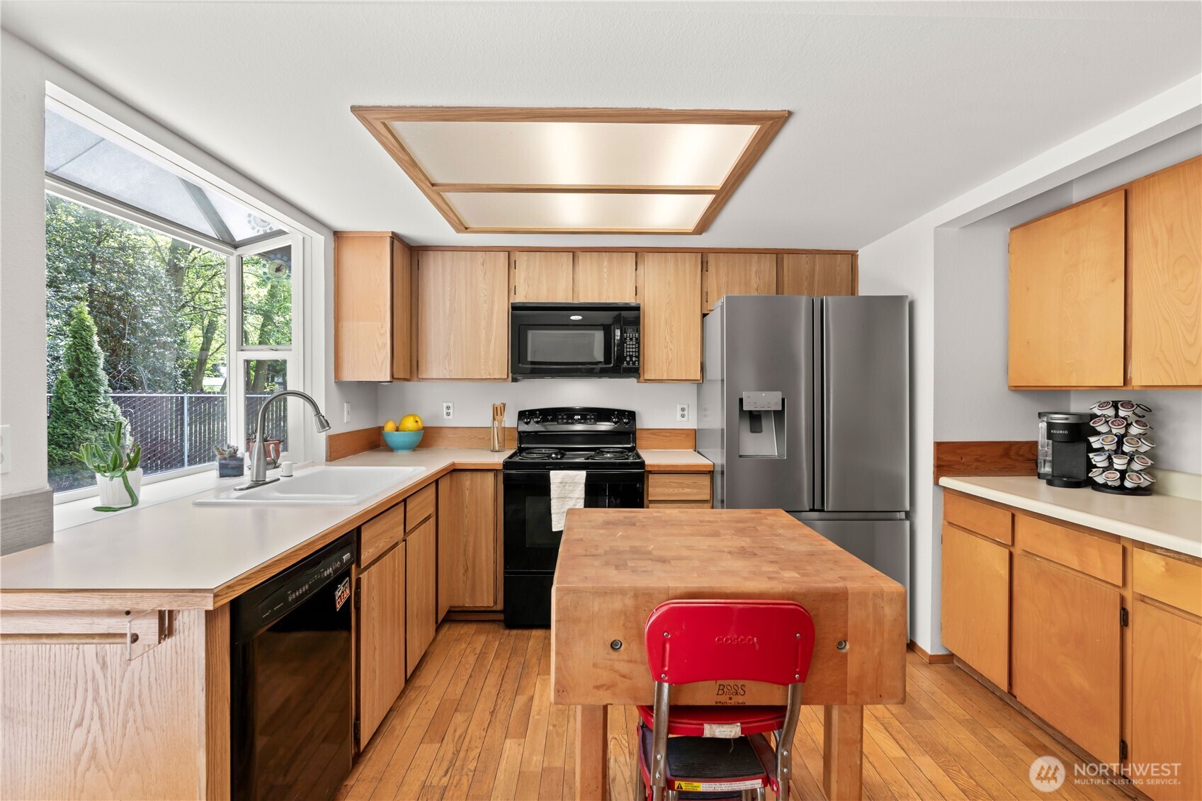 4505 Southwest 317th Place Federal Way, WA 98023 - Photo 12 of 31 a kitchen with stainless steel appliances granite countertop a refrigerator a sink dishwasher a stove a dining table and chairs with wooden floor