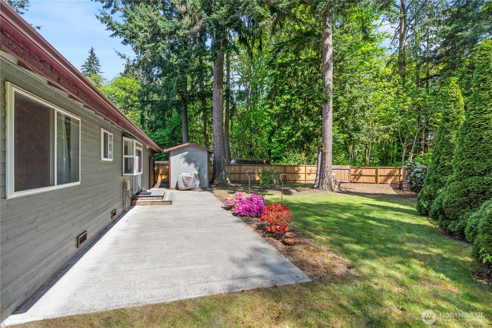 4505 Southwest 317th Place Federal Way, WA 98023 - Photo 19 of 31 a view of backyard with table and chairs and large trees