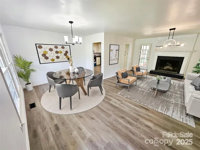 a living room with furniture a fireplace and a chandelier