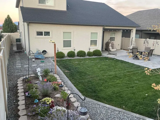 a view of a patio with table and chairs near a yard