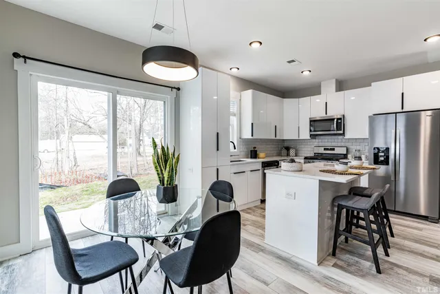 a kitchen with a table chairs refrigerator and cabinets