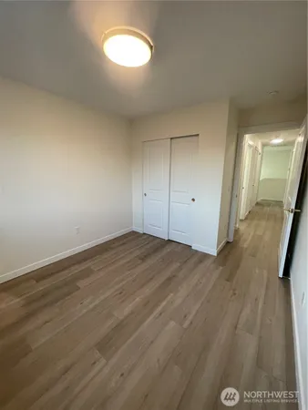 an empty room with wooden floor and mirror