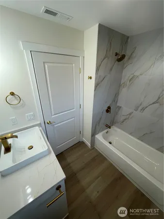 a bathroom with a tub a sink and a shower