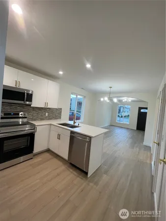 a large kitchen with stainless steel appliances a large counter top a stove a microwave and a refrigerator