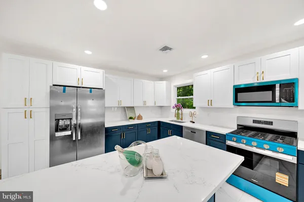 a kitchen with stainless steel appliances a stove sink microwave and refrigerator
