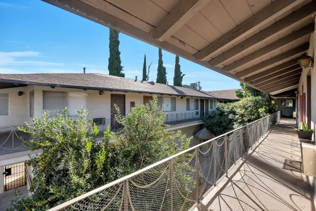 a view of a patio with table and chairs potted plants with wooden floor and fence
