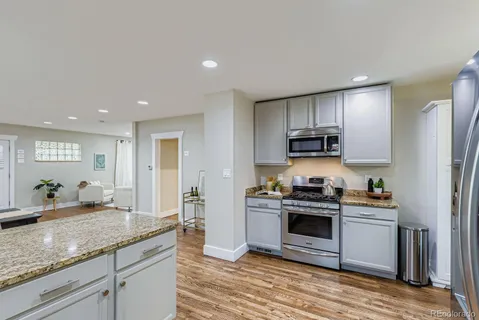 a kitchen with stainless steel appliances granite countertop a stove a sink and a refrigerator
