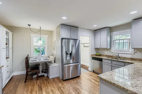 a kitchen with granite countertop a refrigerator stove and sink