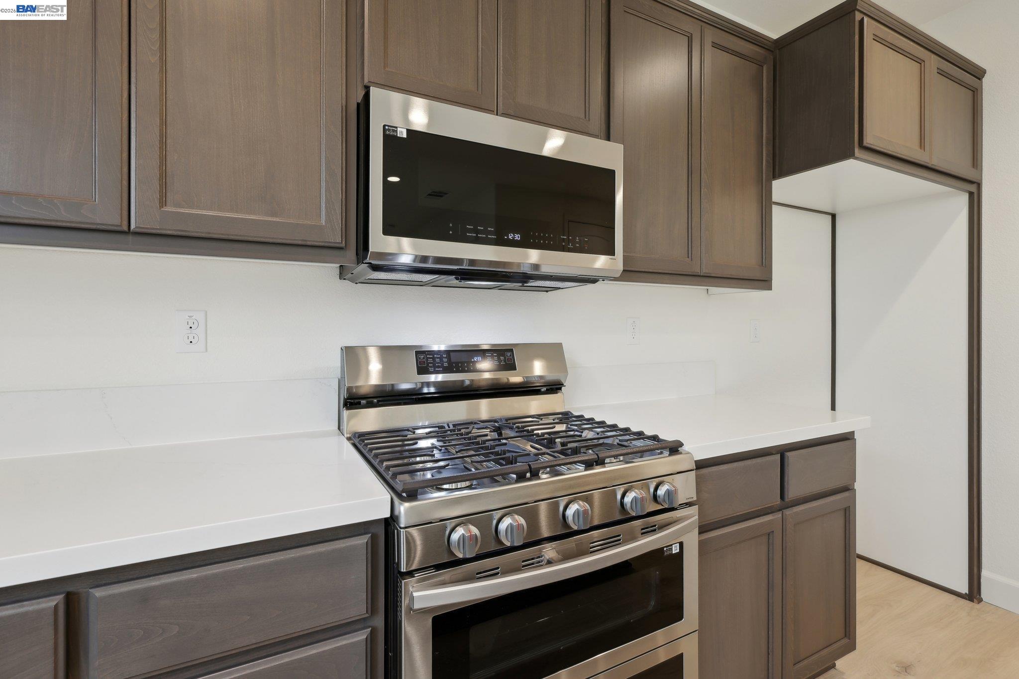 230 Mindy Way Pittsburg, CA 94565 - Photo 13 of 33 a kitchen with stainless steel appliances a stove a microwave and white cabinets