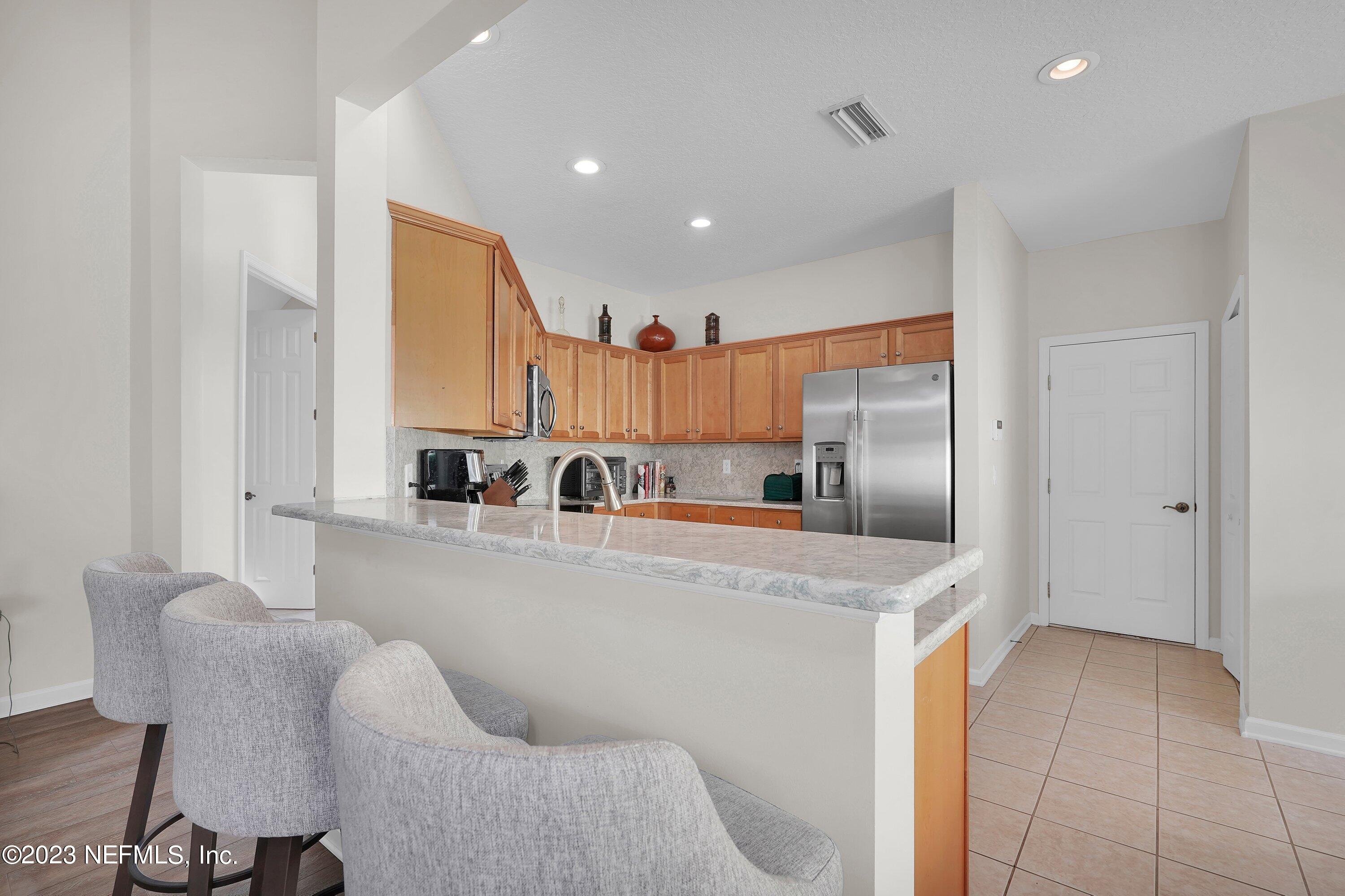 746 Copperhead Circle St. Augustine, FL 32092 - Photo 11 of 40 a kitchen with stainless steel appliances granite countertop a refrigerator a sink and white cabinets