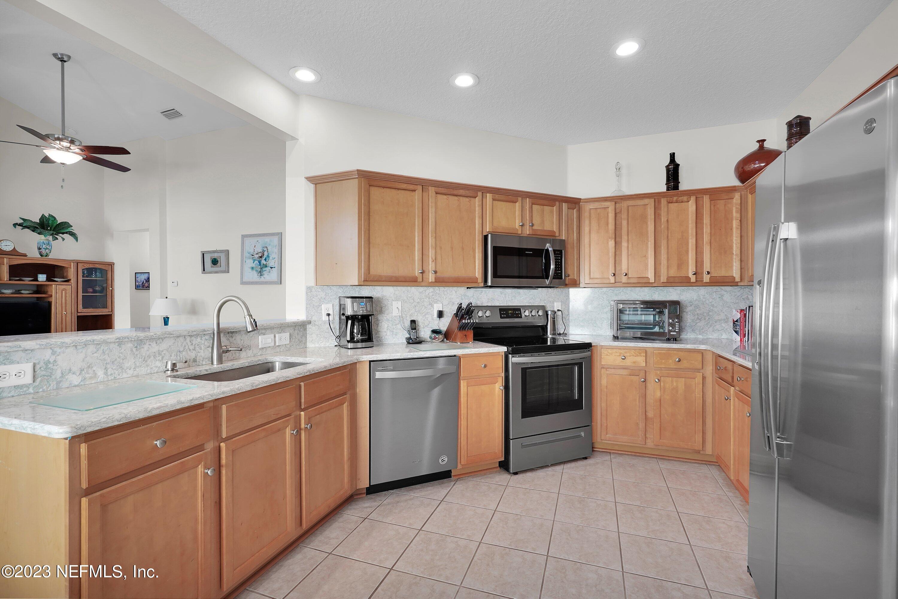 746 Copperhead Circle St. Augustine, FL 32092 - Photo 12 of 40 a kitchen with a sink white cabinets and stainless steel appliances