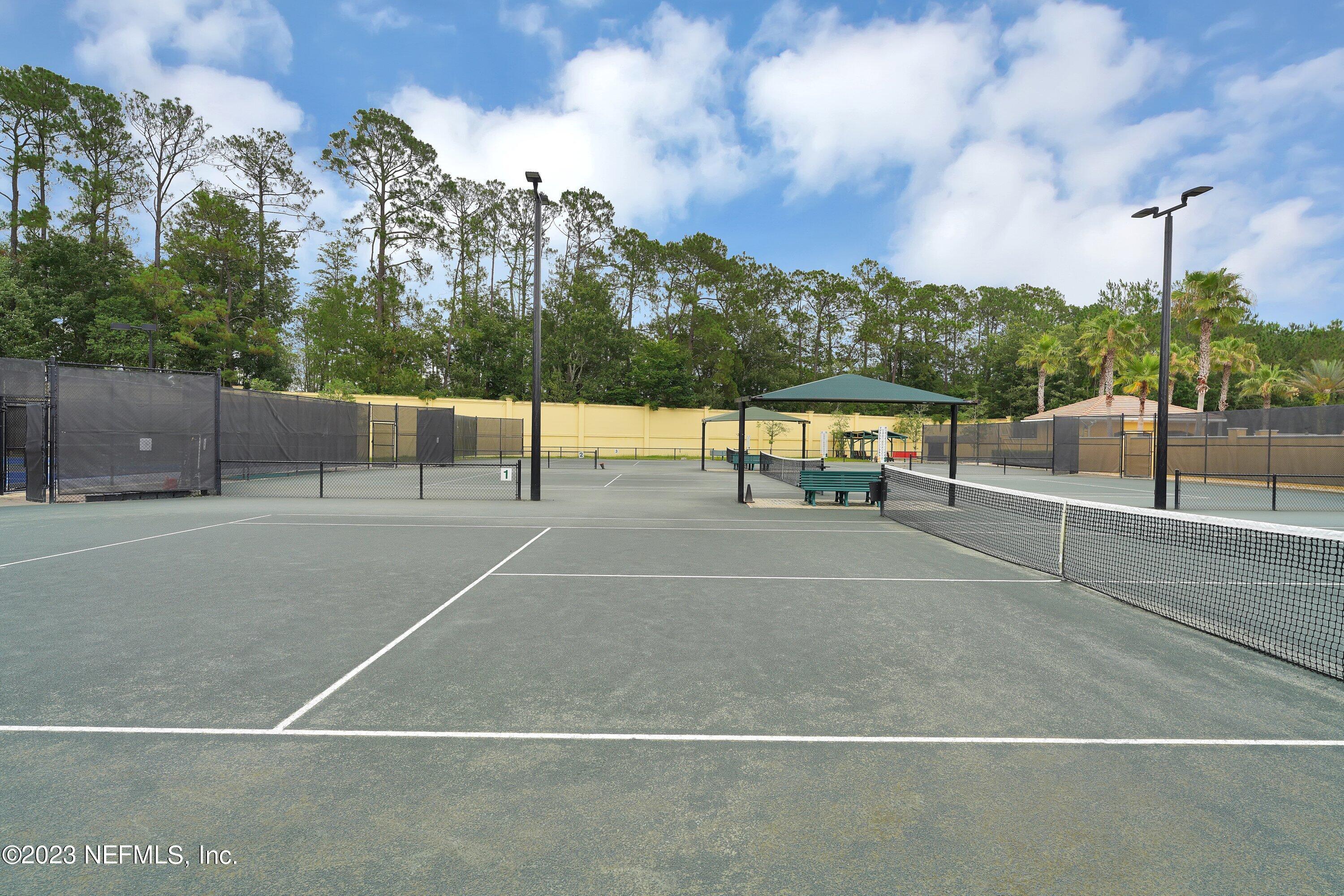 746 Copperhead Circle St. Augustine, FL 32092 - Photo 39 of 40 a view of a tennis court with benches in the background