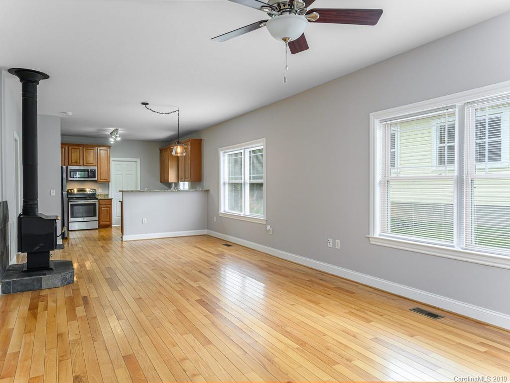 122 Round Top Road Asheville, NC 28803 - Photo 11 of 32 a view of an empty room with a window and wooden floor
