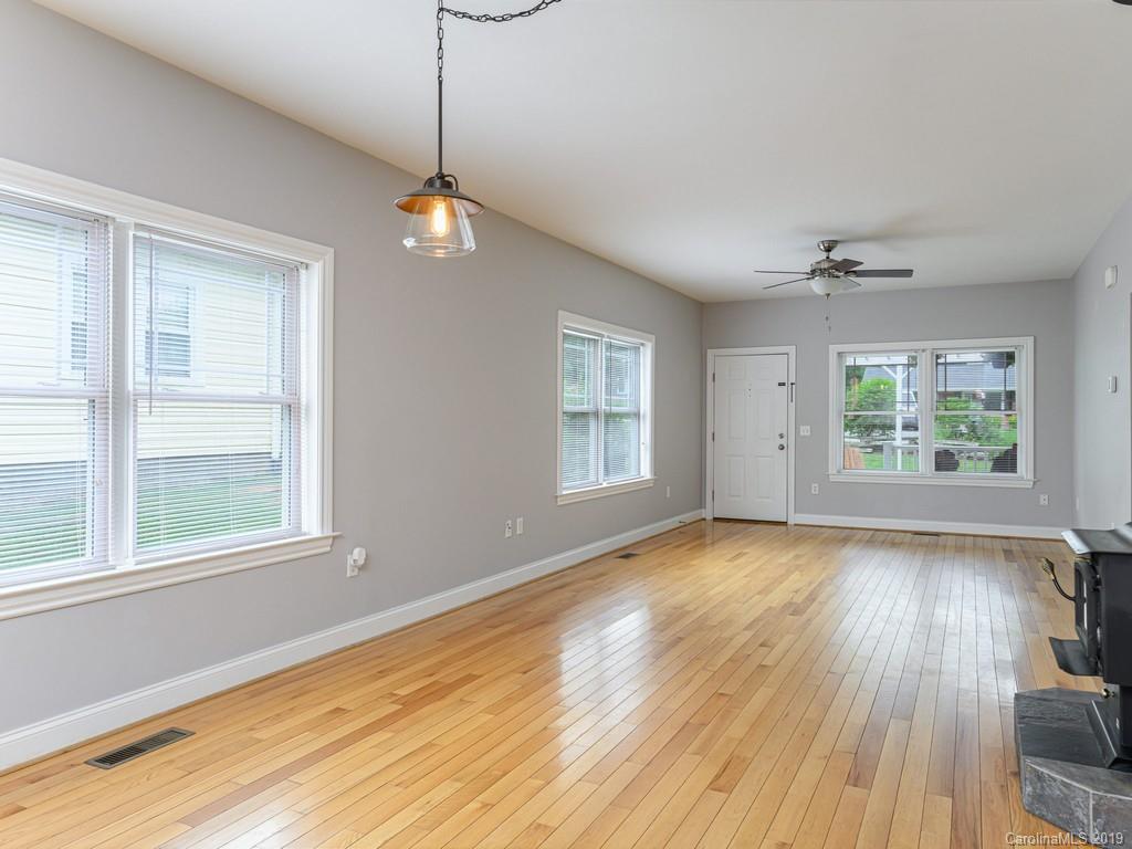 122 Round Top Road Asheville, NC 28803 - Photo 10 of 32 a view of an empty room with wooden floor and a window