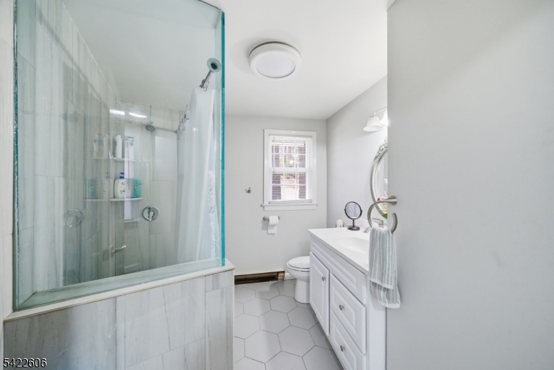 399 Springbrook Trail Sparta, NJ 07871 - Photo 9 of 27 a bathroom with a double vanity sink a mirror and a bathtub