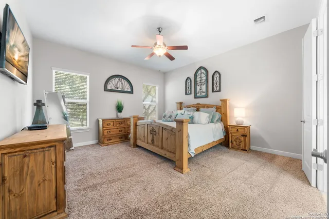 a bedroom with a bed and a flat tv screen on dresser