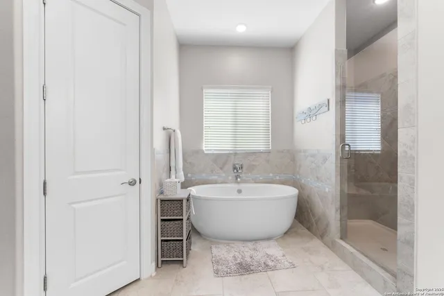 a spacious bathroom with a bathtub and shower