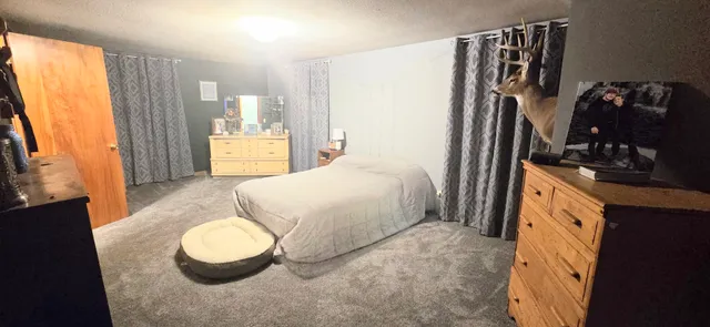 a spacious bedroom with a bed and a flat tv screen