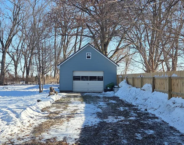 a front view of a house with a yard covered in snow