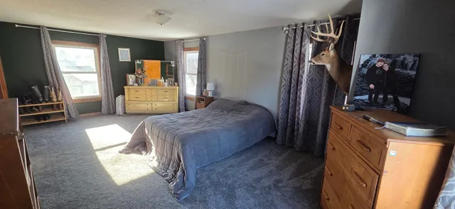a spacious bedroom with a bed and a large mirror in it