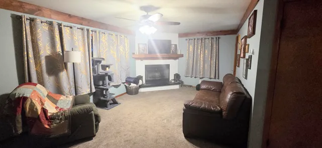 a living room with furniture fireplace and a large window