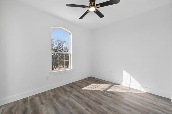 a view of a room with wooden floor and ceiling fan