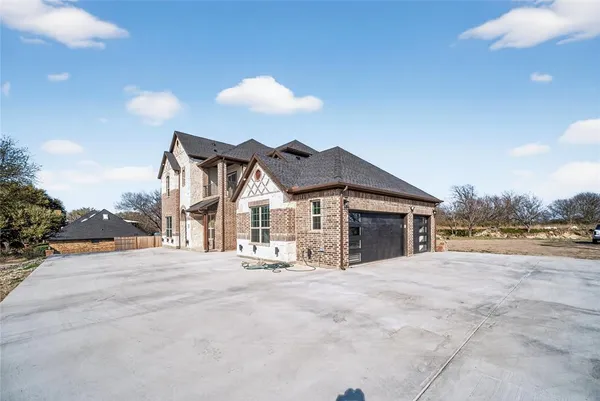 a view of a house with a patio and a yard