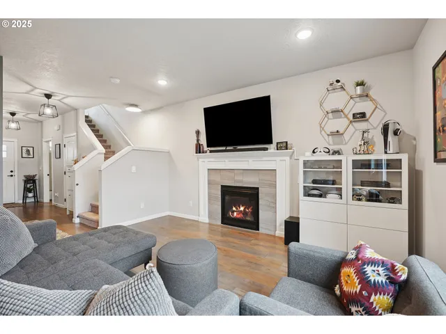 a living room with furniture a flat screen tv and a fireplace
