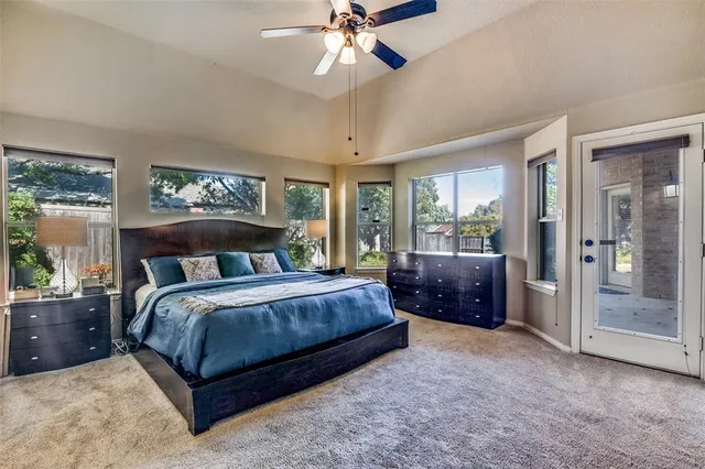 a bedroom with a large bed and a chandelier fan