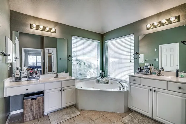 a large white bathroom with a large tub sink and mirror