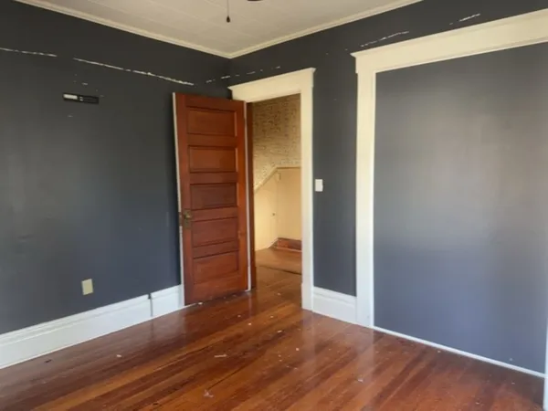 a view of an empty room with wooden floor