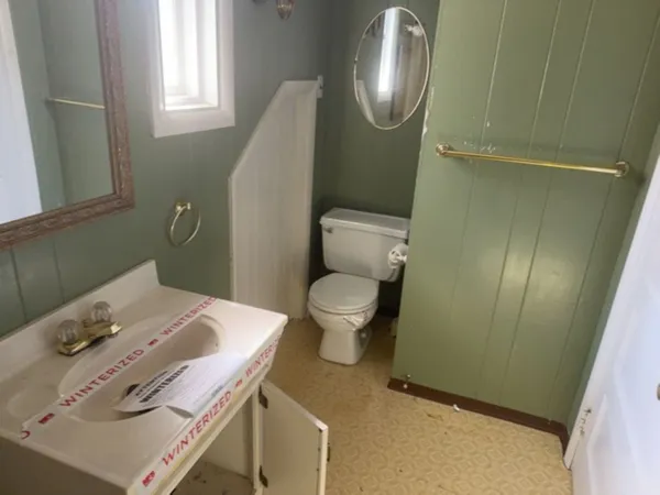a bathroom with a sink toilet and a mirror
