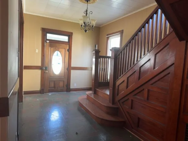 a view of a livingroom with wooden floor and stairs