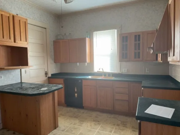 a kitchen with sink a window and cabinets