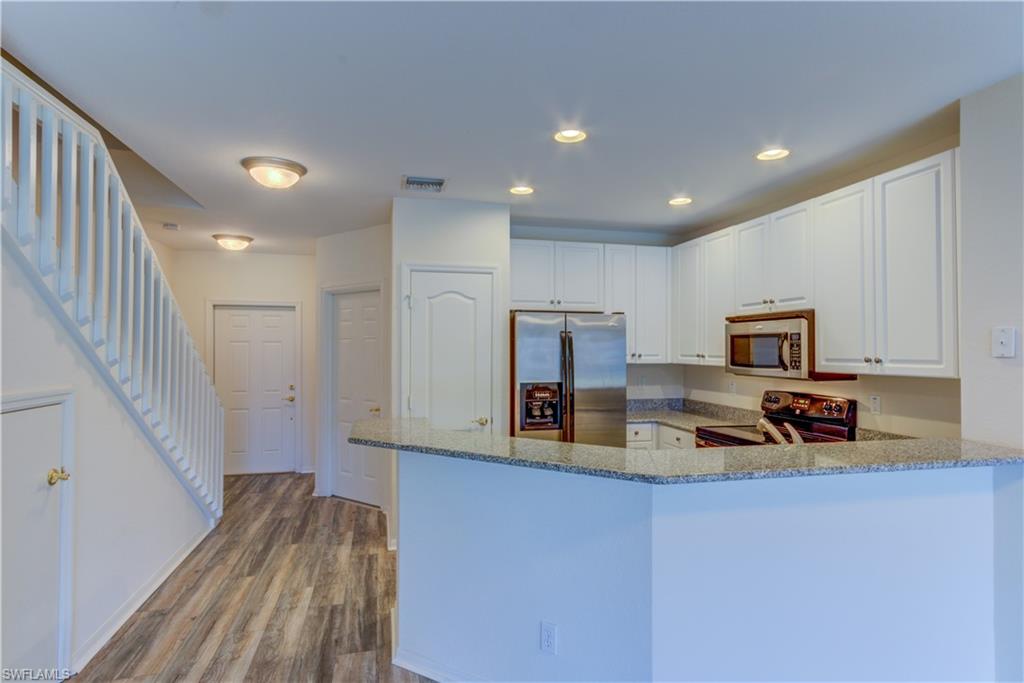 11719 Eros Road Lehigh Acres, FL 33971 - Photo 3 of 20 a kitchen with a refrigerator and a stove top oven