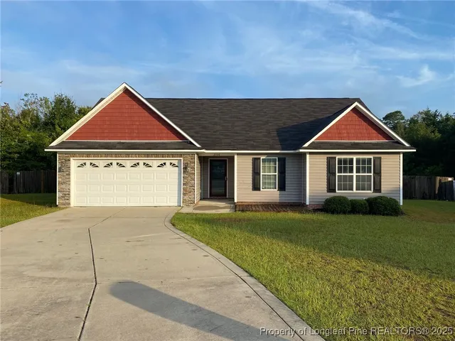 a front view of a house with a garden and yard