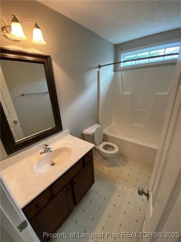a bathroom with a sink vanity mirror and toilet