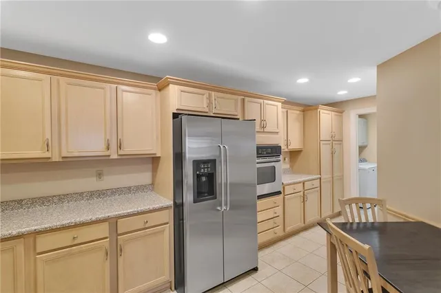 a kitchen with stainless steel appliances granite countertop a refrigerator and a sink