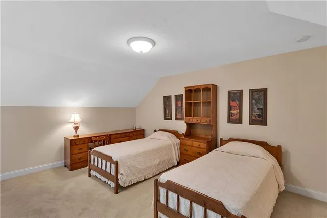 a bedroom with two beds and painting on the wall