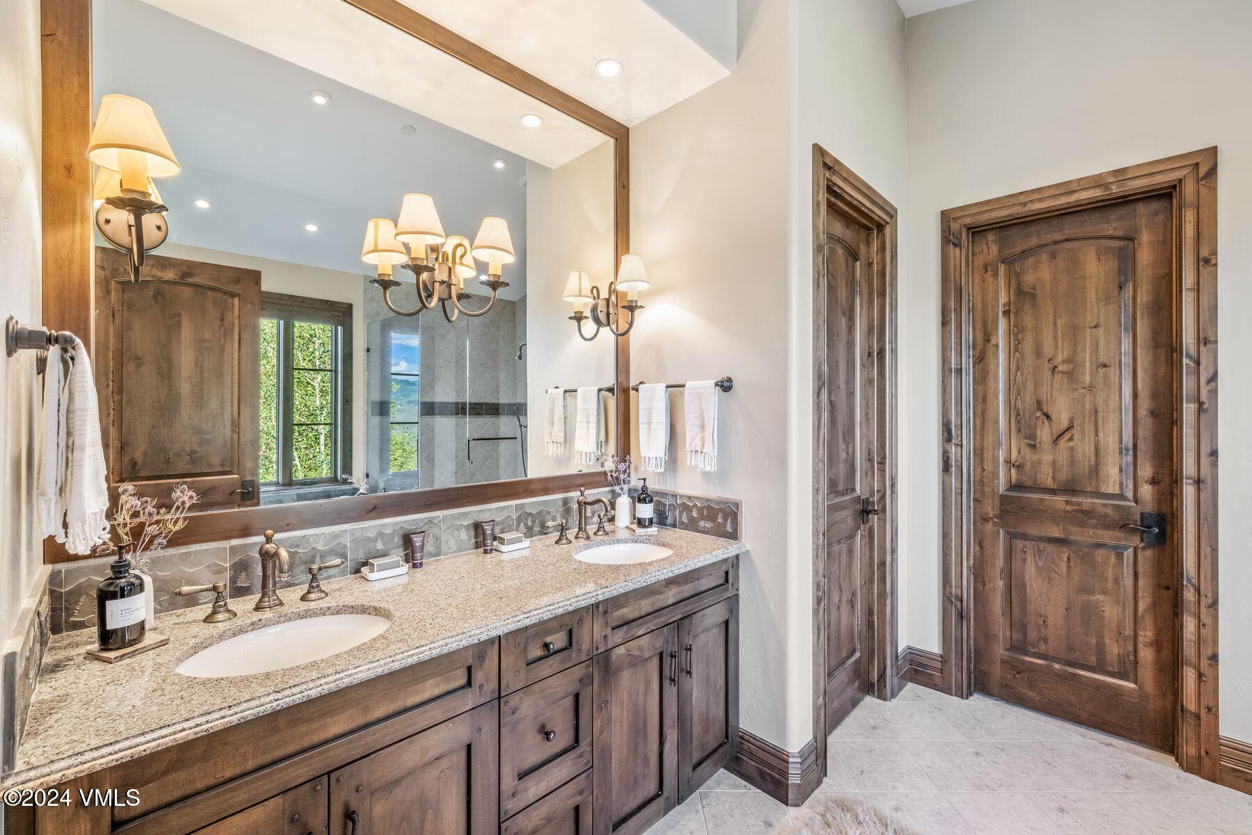 76 Setting Sun Lane Wolcott, CO 81655 - Photo 49 of 79 a bathroom with a granite countertop sink a large mirror and a shower