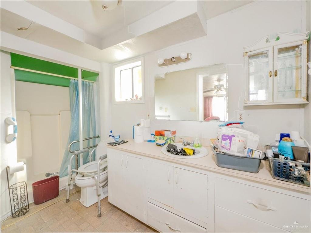 23067 Cragon Road Harlingen, TX 78552 - Photo 11 of 28 a bathroom with a sink mirror vanity and toilet