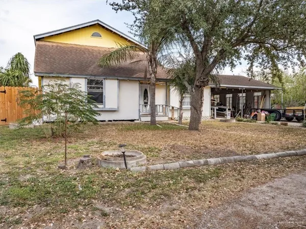 a view of a house with a large tree and a yard