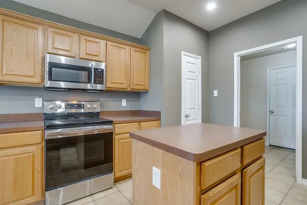 a kitchen with granite countertop cabinets stainless steel appliances and a counter space
