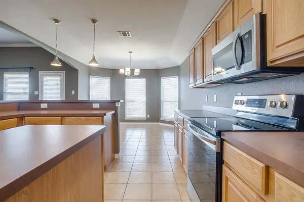 a kitchen with stainless steel appliances granite countertop a sink a stove counter space and cabinets
