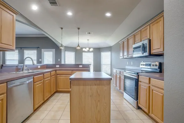 a large kitchen with stainless steel appliances lots of counter space and a sink