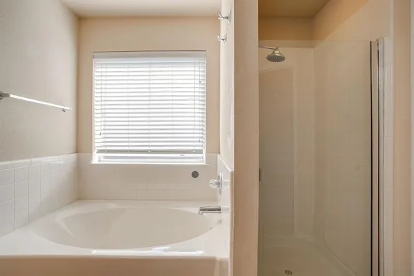 a bathroom with a bathtub next to a window