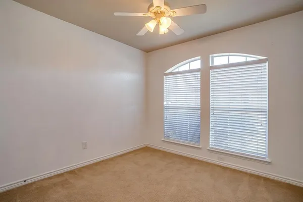 an empty room with a window and a ceiling fan